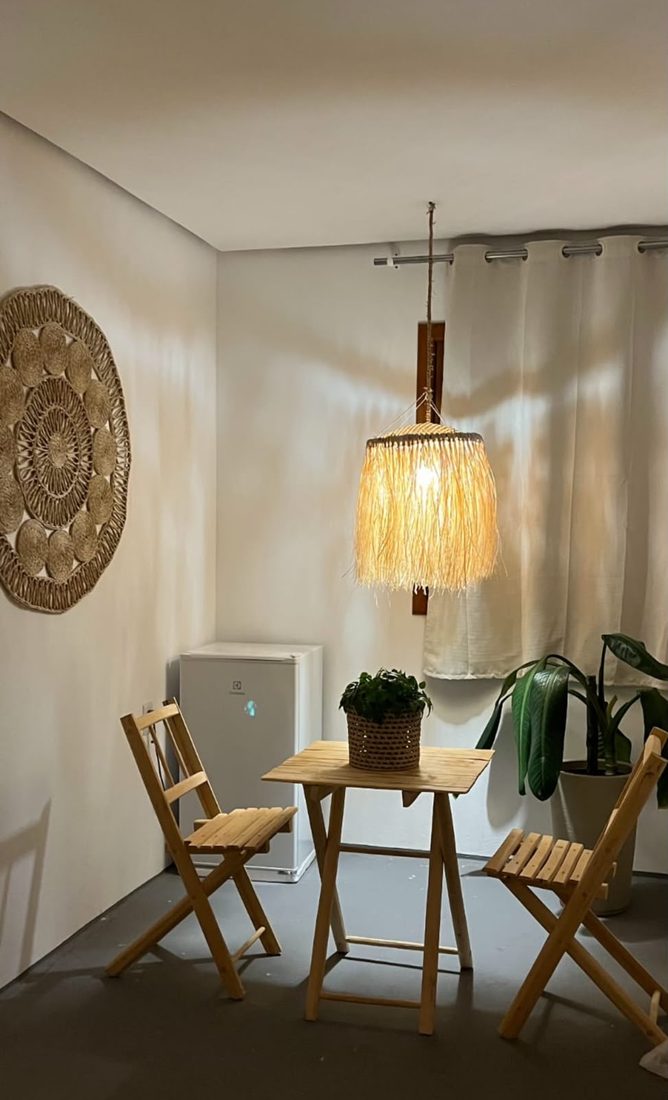 Cantinho com mesa, cadeiras e frigobar