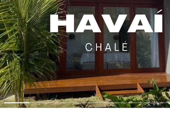 Fachada do Chalé Havaí, com deck de madeira e porta de vidro