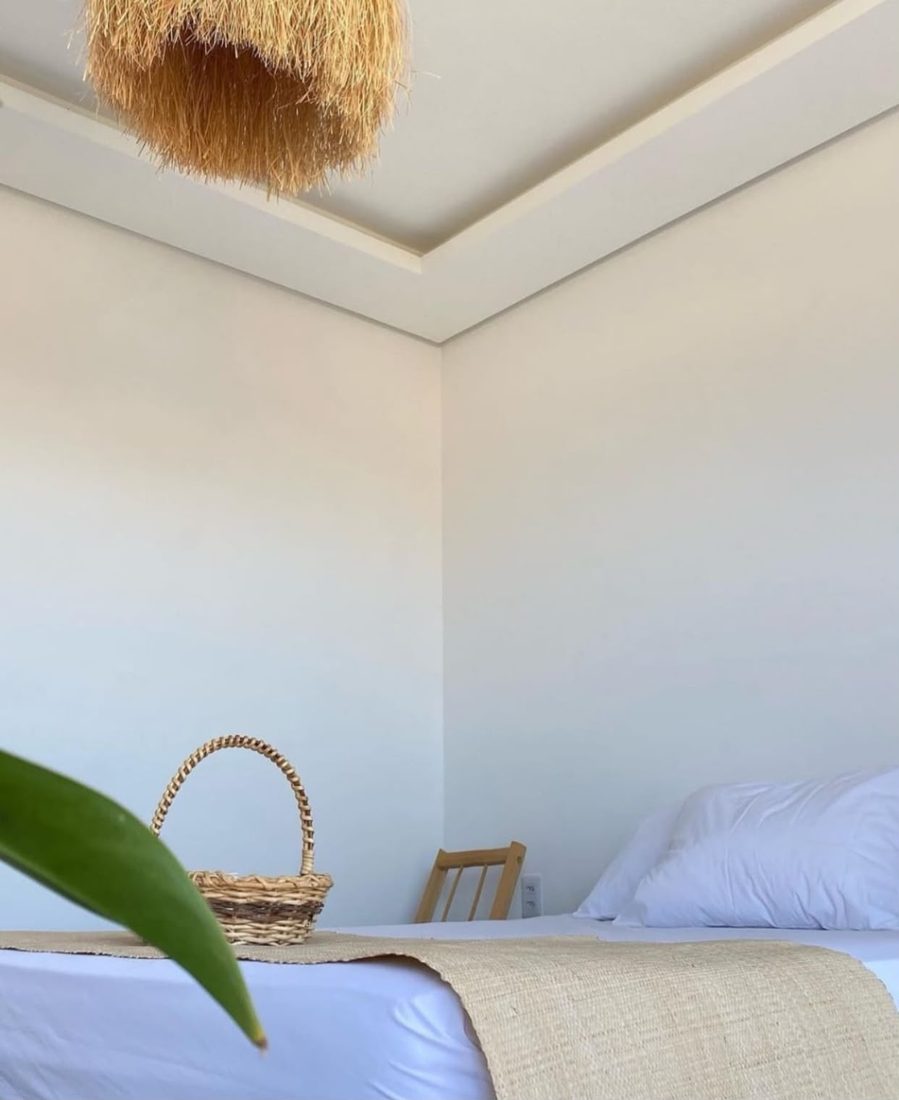 Quarto simples com cama e cesto de amenities